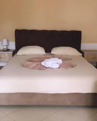 a white towel sitting on top of a bed at S T A Apartmani in Ulcinj