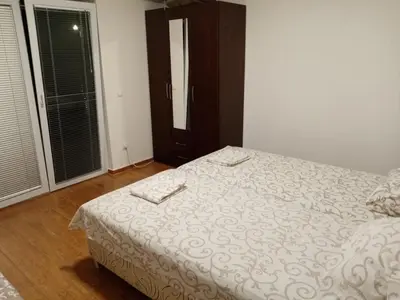 a bedroom with a bed with white sheets and a window at Malina apartman in Utjeha