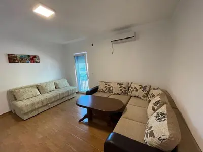 a living room with a couch and a table at Malina apartman in Utjeha