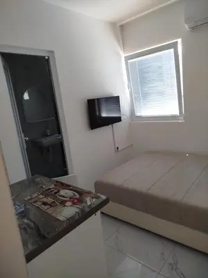 a small bedroom with a bed and a mirror at Malina apartman in Utjeha