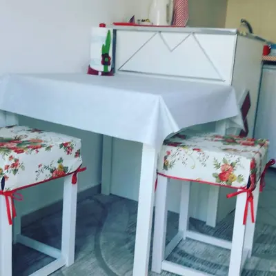 a white table and two chairs with red bows at Apartmani Dačo in Sveti Stefan