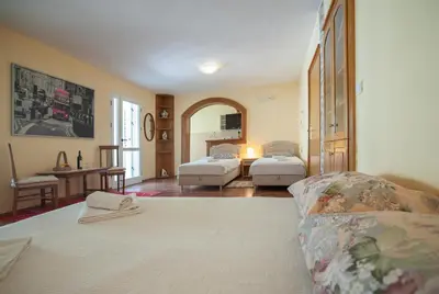 a room with two beds and a couch in it at Apartmani Dačo in Sveti Stefan