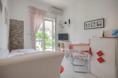 a room with a bed and a table and a window at Apartmani Dačo in Sveti Stefan
