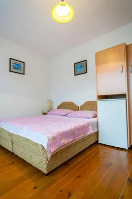 a bedroom with a large bed and a refrigerator at Rooms Molabeciri in Ulcinj
