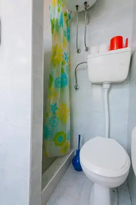 a bathroom with a toilet and a shower curtain at Rooms Molabeciri in Ulcinj