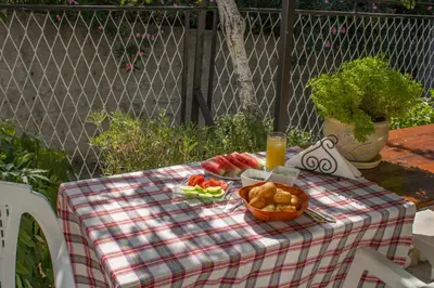 a picnic table with a basket of fruit and a glass of orange juice at Rooms Molabeciri in Ulcinj