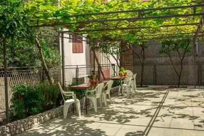 a patio with tables and chairs under a pergola at Rooms Molabeciri in Ulcinj