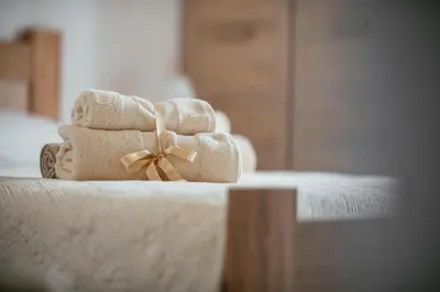 a pile of towels with a bow on a bed at Big Hill Apartment in Kotor