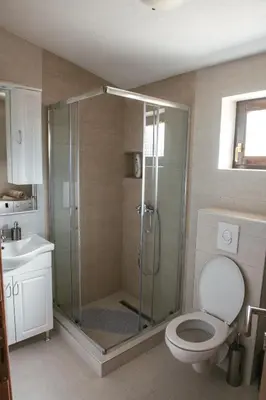 a bathroom with a shower with a toilet and a sink at Big Hill Apartment in Kotor