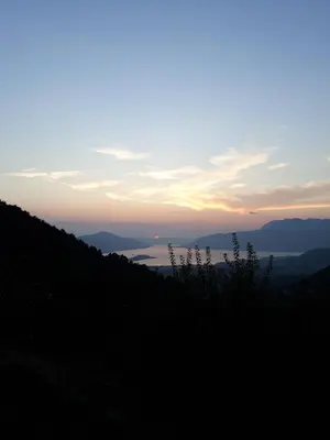 a sunset over a hill with a view of the ocean at Big Hill Apartment in Kotor