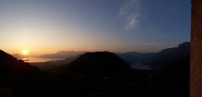 a view of the sun setting over a mountain range at Big Hill Apartment in Kotor