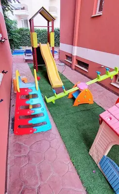 a playground with colorful play equipment in a yard at Villa Bojana in Budva