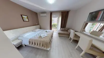 a bedroom with a bed and a desk and window at Villa Bojana in Budva