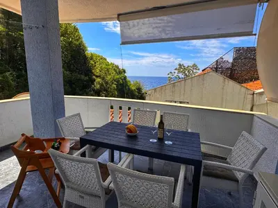 a table on a balcony with a view of the ocean at Apartment M&M in Sveti Stefan