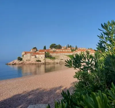 a beach with a group of houses in the background at Apartment M&M in Sveti Stefan