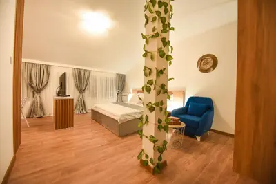 a hotel room with a bed and a blue chair at Korzo apartmani in Podgorica