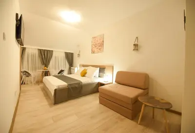 a hotel room with a bed and a chair at Korzo apartmani in Podgorica