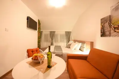 a room with a bed and a table with a wine bottle at Korzo apartmani in Podgorica
