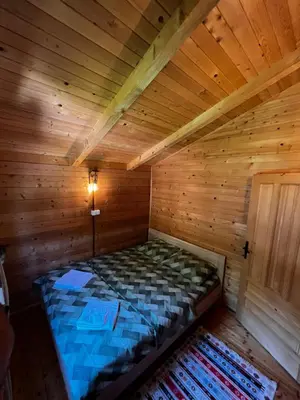 a bed in a wooden room in a cabin at Orahovo Cottages in Virpazar