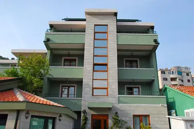 a building with a ladder on the side of it at Apartments Krapina in Budva