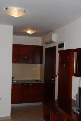 a kitchen with wooden cabinets and a ceiling at Apartments Krapina in Budva