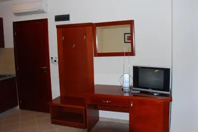 a room with a tv and a dresser with a mirror at Apartments Krapina in Budva