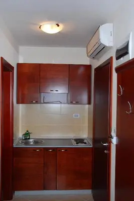 a kitchen with wooden cabinets and a sink at Apartments Krapina in Budva