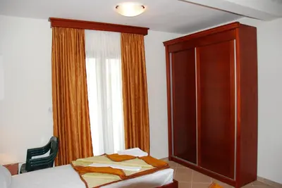 a bedroom with a bed and a cabinet and a window at Apartments Krapina in Budva