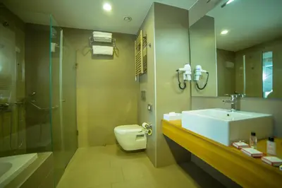 a bathroom with a sink and a toilet and a shower at Ramada by Wyndham Podgorica in Podgorica