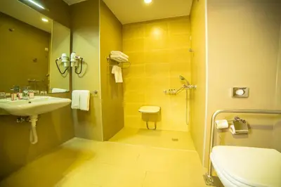 a bathroom with a sink and a toilet and a shower at Ramada by Wyndham Podgorica in Podgorica