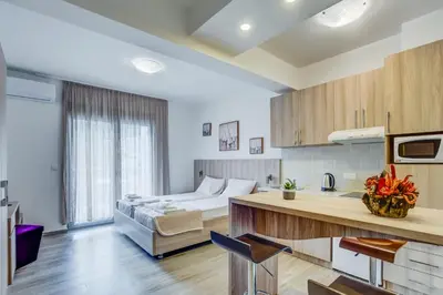 a bedroom with a bed and a kitchen with a counter at Adriatik Lux Apartments in Budva