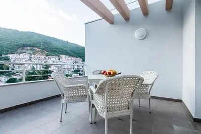 a dining room with a table and chairs on a balcony at Adriatik Lux Apartments in Budva