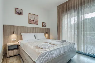 a bedroom with a large bed and a large window at Adriatik Lux Apartments in Budva