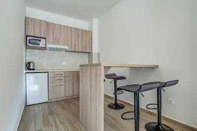 a kitchen with two bar stools and a counter at Adriatik Lux Apartments in Budva