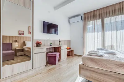 a bedroom with a bed and a mirror at Adriatik Lux Apartments in Budva