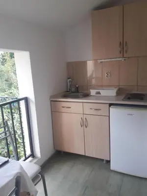 a kitchen with wooden cabinets and a white refrigerator at Apartmani Bugarski in Rafailovici