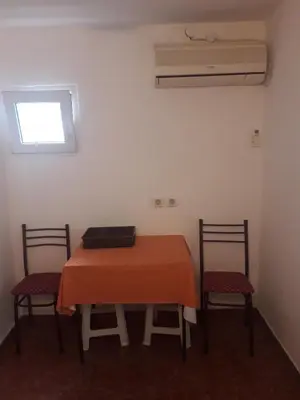 a room with a table with two chairs and a window at Apartmani Bugarski in Rafailovici