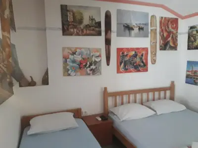 two beds in a room with pictures on the wall at Apartmani Bugarski in Rafailovici