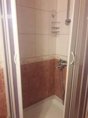 a shower with a glass door in a bathroom at Apartmani Bugarski in Rafailovici