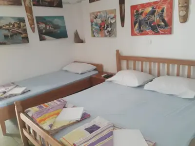 two beds in a room with paintings on the wall at Apartmani Bugarski in Rafailovici