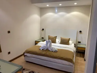 a bedroom with a large bed with two tables at Hotel Fobra in Podgorica
