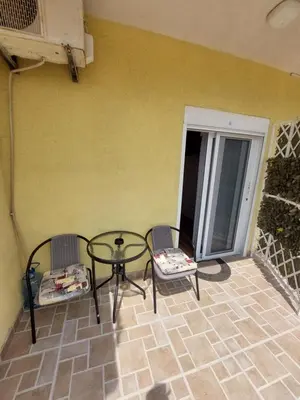 a patio with two chairs and a glass table at Apartments South in Ulcinj