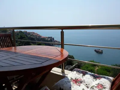 a balcony with a table and a view of the ocean at Apartments South in Ulcinj