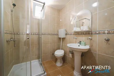 a bathroom with a shower toilet and a sink at Apartments South in Ulcinj
