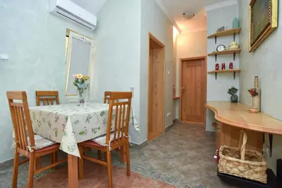 a dining room with a table and some chairs and a table and a table at Comfort Inn Old Town in Budva
