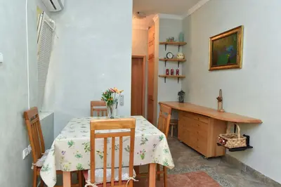a dining room with a table and a desk at Comfort Inn Old Town in Budva