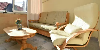a living room with a couch and a rocking chair at Comfort Inn Old Town in Budva