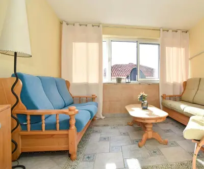 a living room with a blue couch and a table at Comfort Inn Old Town in Budva