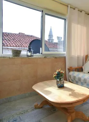 a living room with a table and a window at Comfort Inn Old Town in Budva