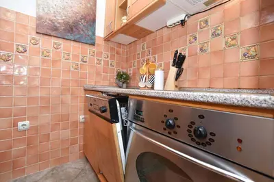 a kitchen with a dishwasher and pink tiles at Comfort Inn Old Town in Budva